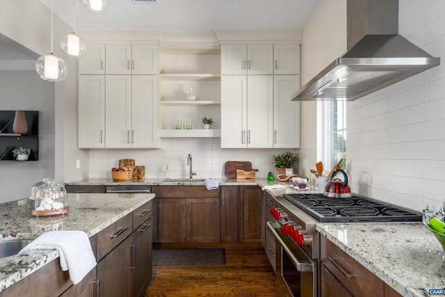 kitchen featuring white cabinets, backsplash, wall chimney range hood, range with two ovens, and dark hardwood / wood-style flooring