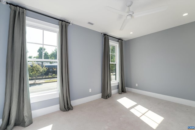 empty room featuring ceiling fan and light colored carpet