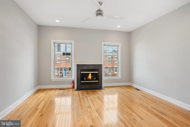 unfurnished living room featuring ceiling fan and light hardwood / wood-style flooring