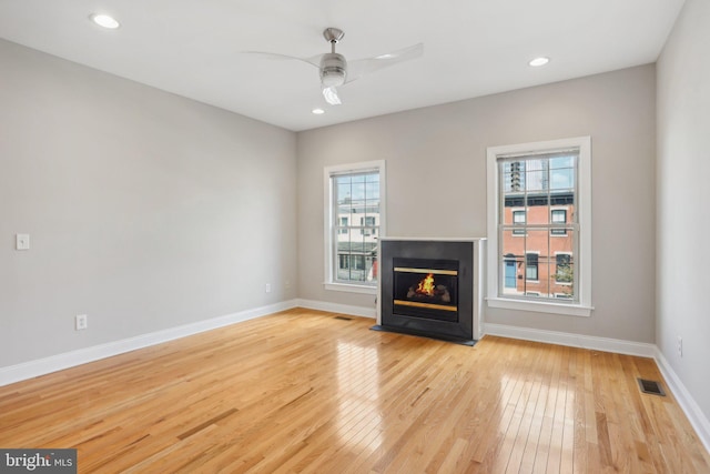 unfurnished living room with ceiling fan and light hardwood / wood-style floors