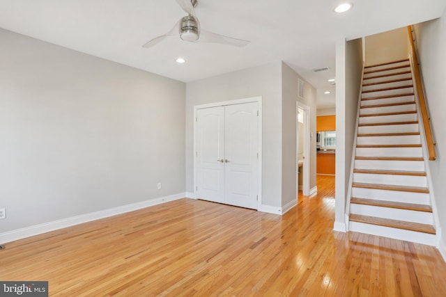 unfurnished bedroom featuring light wood-type flooring, ceiling fan, and a closet