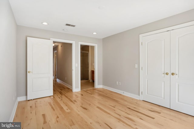 unfurnished bedroom with light hardwood / wood-style flooring and a closet