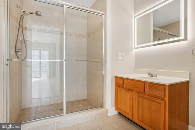 bathroom with vanity, a shower with door, and tile patterned floors