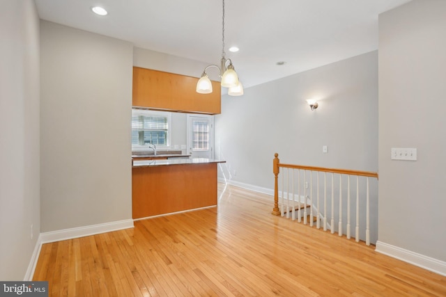 interior space featuring light wood-type flooring and a notable chandelier