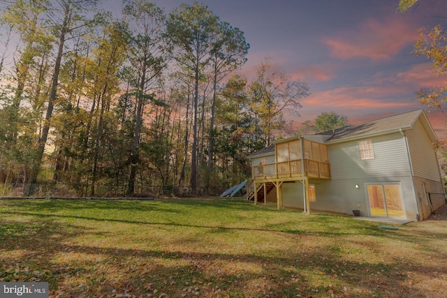 yard at dusk featuring a deck