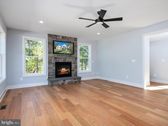 unfurnished living room with light hardwood / wood-style flooring, a fireplace, and ceiling fan