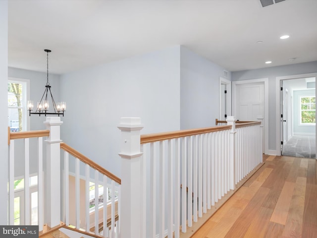 hallway featuring a chandelier and light hardwood / wood-style floors