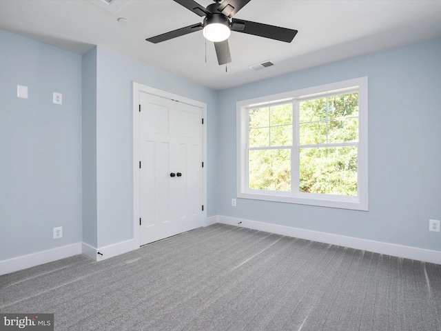 unfurnished room featuring carpet floors, a healthy amount of sunlight, and ceiling fan