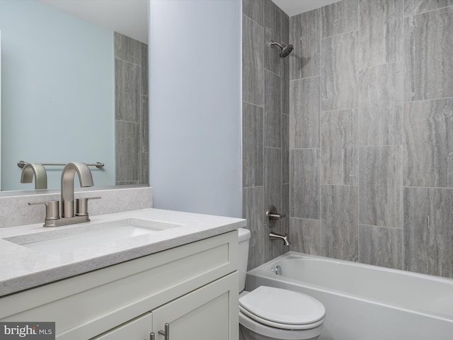 full bathroom featuring toilet, tiled shower / bath, and vanity