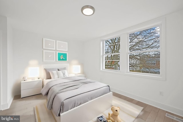 bedroom featuring light wood-type flooring and multiple windows