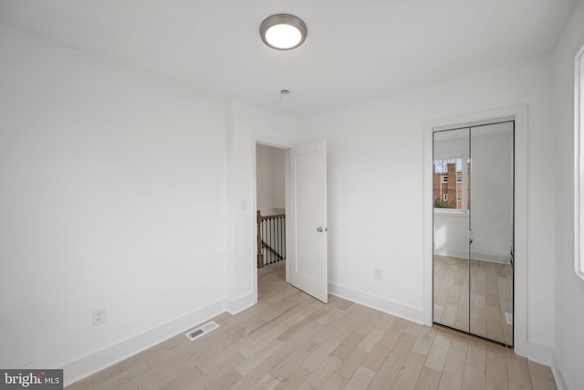 unfurnished bedroom featuring a closet and light hardwood / wood-style floors