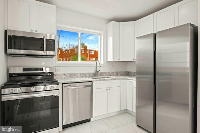 kitchen featuring stainless steel appliances, white cabinets, and sink