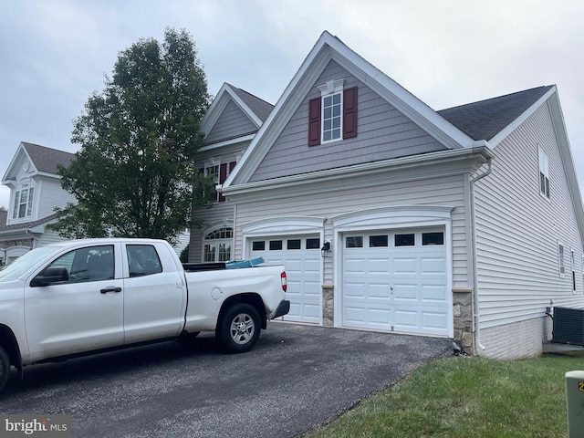 exterior space featuring central AC unit and a garage