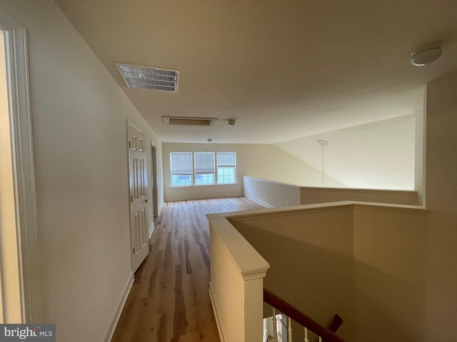 hallway featuring hardwood / wood-style flooring and lofted ceiling