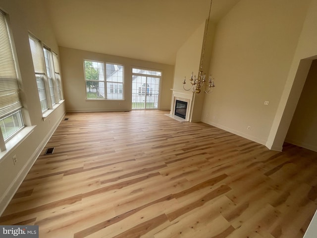 unfurnished living room featuring light wood-type flooring and lofted ceiling