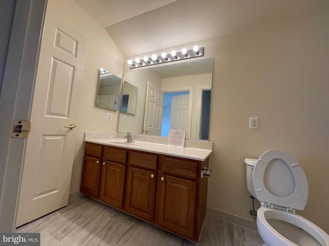 bathroom featuring vaulted ceiling, vanity, and toilet