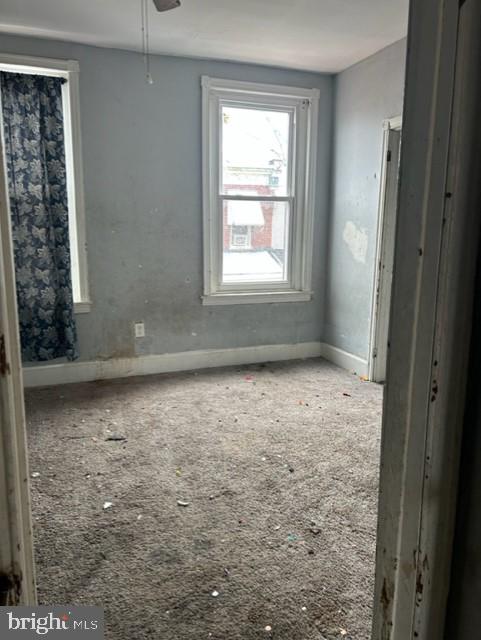 unfurnished room with ceiling fan and carpet flooring