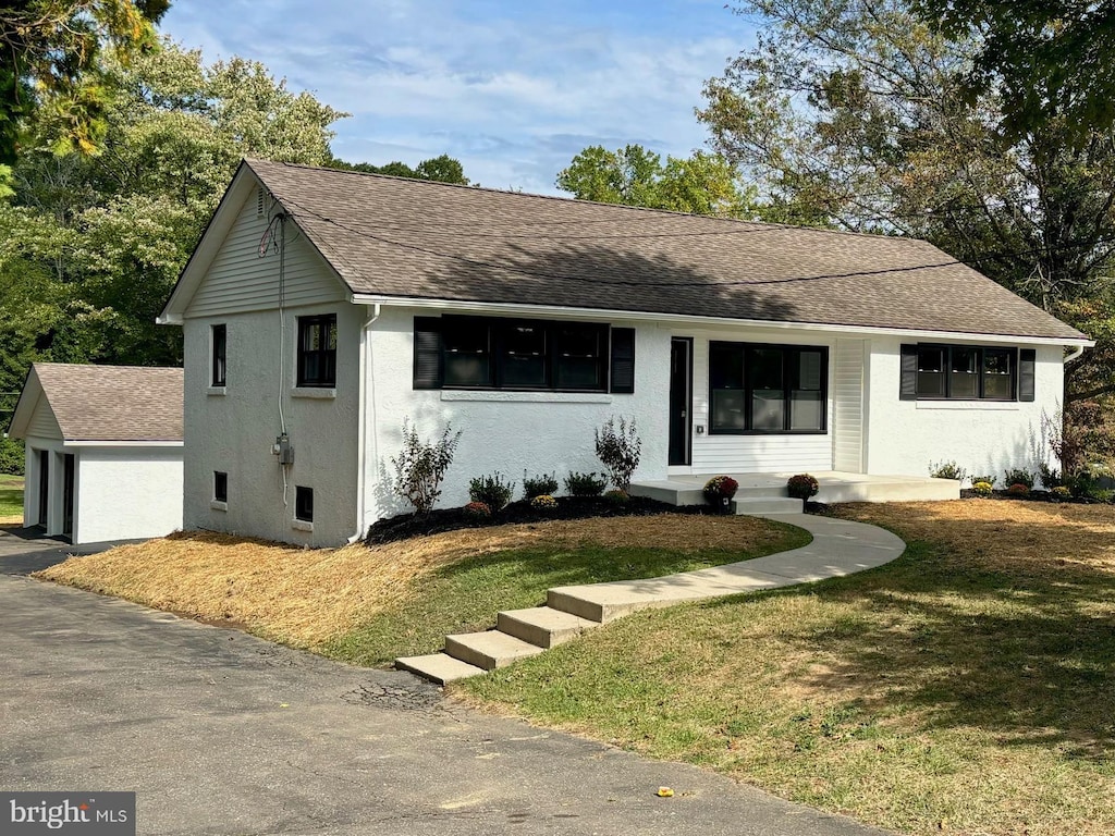 view of front of home with a front yard and a garage