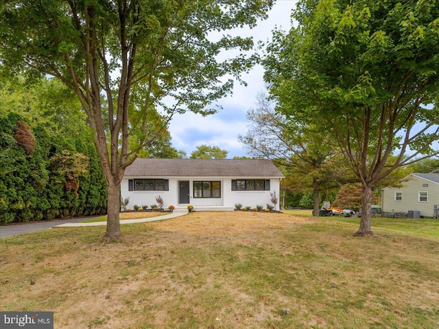 ranch-style home with central AC unit and a front yard