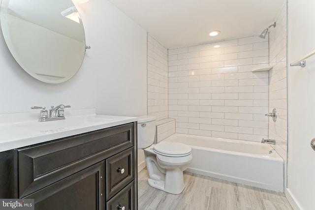 full bathroom with hardwood / wood-style floors, vanity, toilet, and tiled shower / bath