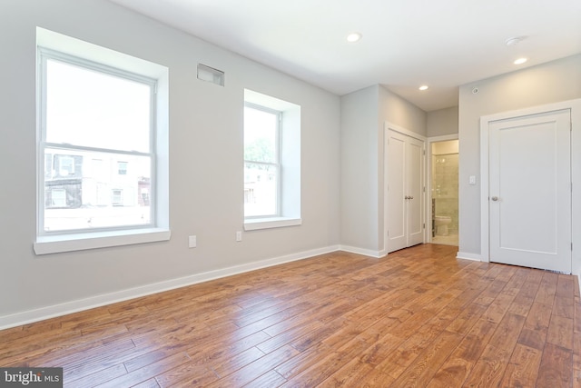 unfurnished bedroom featuring light hardwood / wood-style flooring and ensuite bathroom