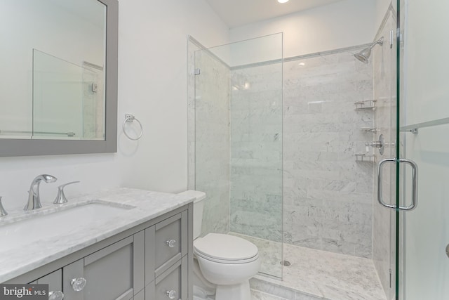 bathroom featuring vanity, toilet, and a shower with door