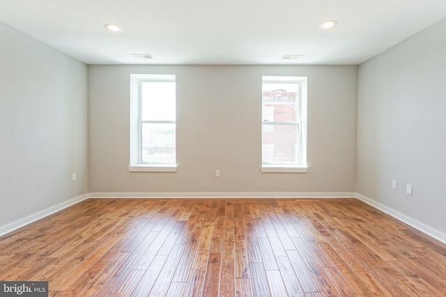 spare room featuring light wood-type flooring and a wealth of natural light