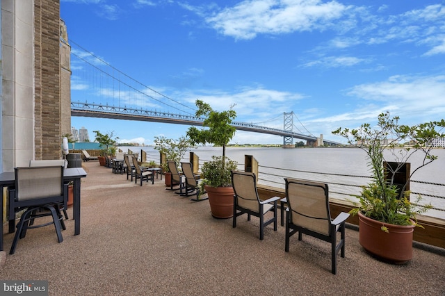 view of patio featuring a balcony and a water view