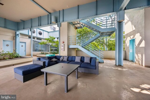 hall with a baseboard heating unit, light carpet, and plenty of natural light