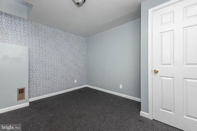 unfurnished room with dark colored carpet