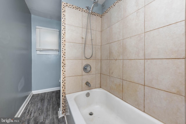 bathroom with tiled shower / bath combo and hardwood / wood-style floors