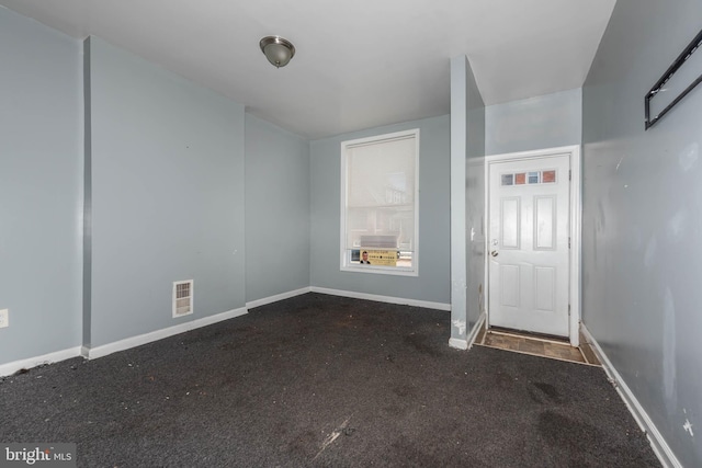 entrance foyer featuring dark colored carpet