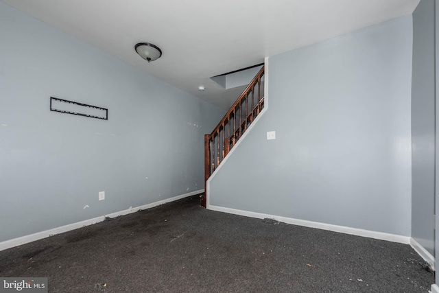 unfurnished living room featuring dark colored carpet