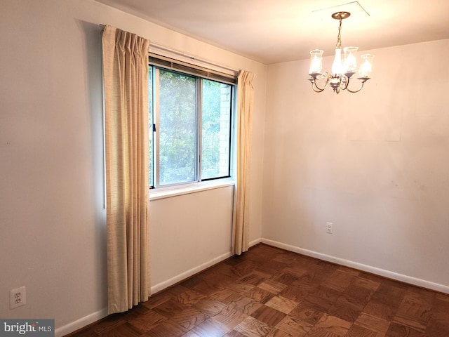 unfurnished room featuring a notable chandelier and dark parquet flooring