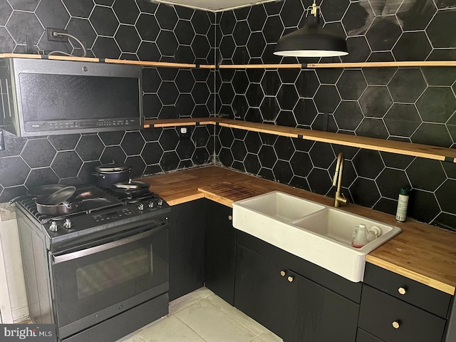 kitchen featuring light tile patterned floors, backsplash, stainless steel appliances, and sink