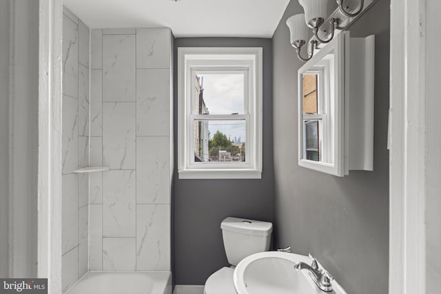 full bathroom featuring sink, tiled shower / bath, and toilet