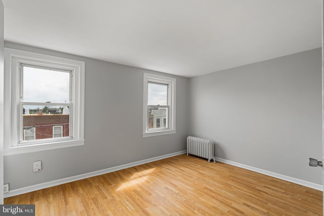 empty room with radiator and light hardwood / wood-style flooring