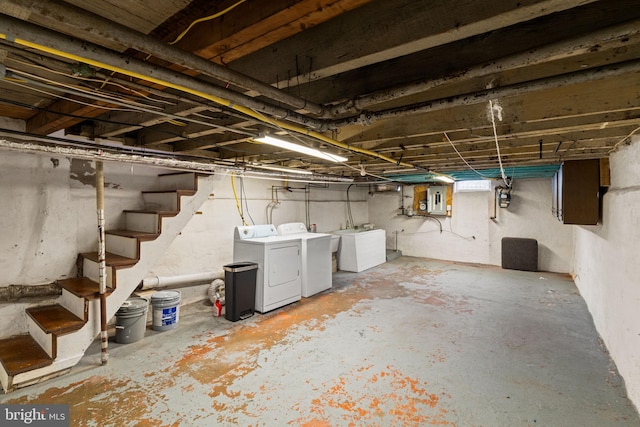 basement featuring electric panel and washing machine and clothes dryer