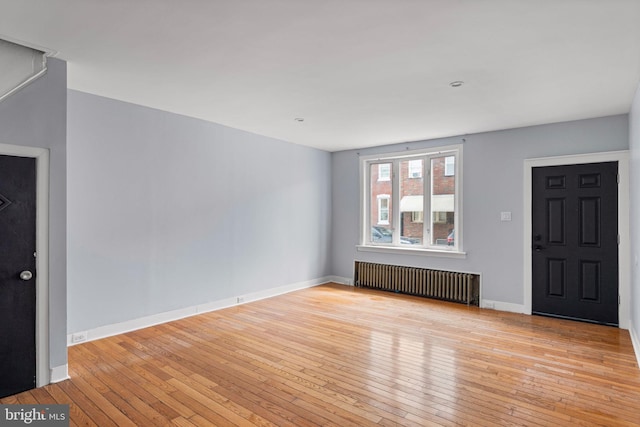 foyer entrance featuring radiator and light hardwood / wood-style flooring