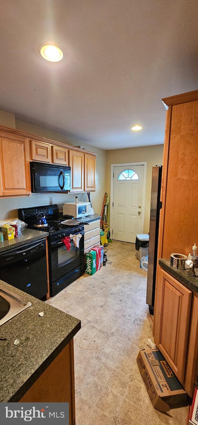 kitchen featuring black appliances and dark stone countertops