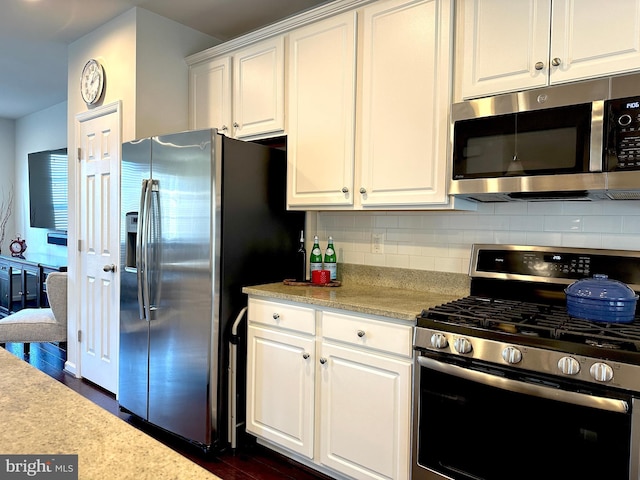 kitchen featuring decorative backsplash, white cabinets, dark hardwood / wood-style floors, and appliances with stainless steel finishes