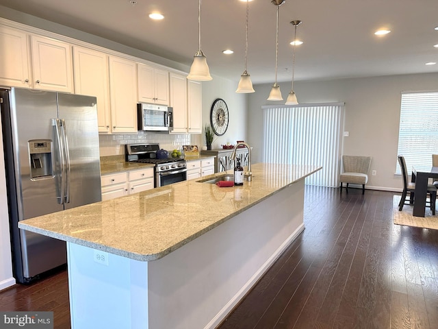 kitchen featuring white cabinets, a large island, sink, and appliances with stainless steel finishes