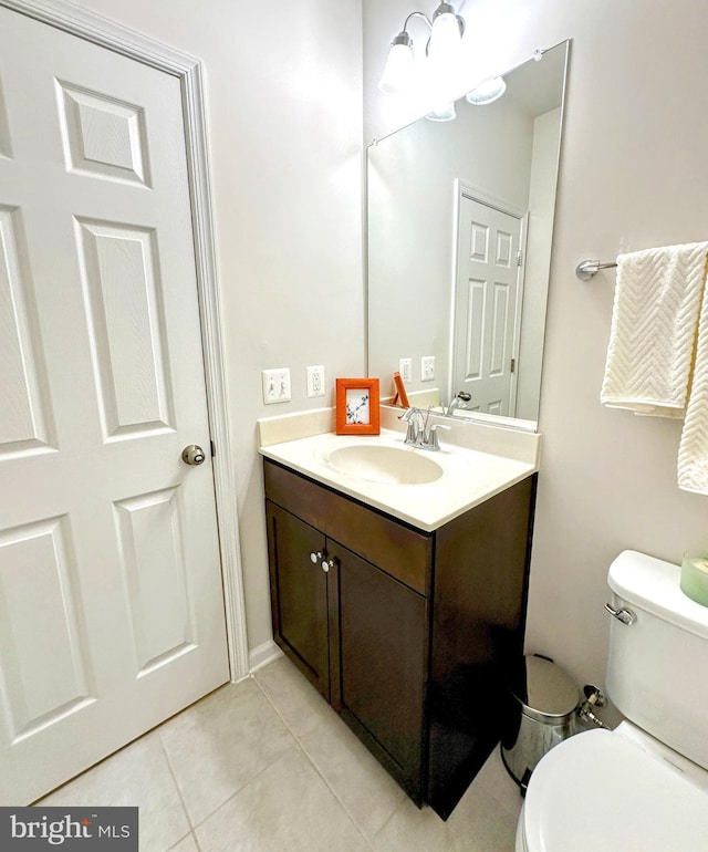 bathroom with tile patterned flooring, vanity, and toilet