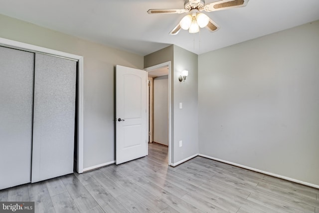 unfurnished bedroom featuring light wood-type flooring, ceiling fan, and a closet