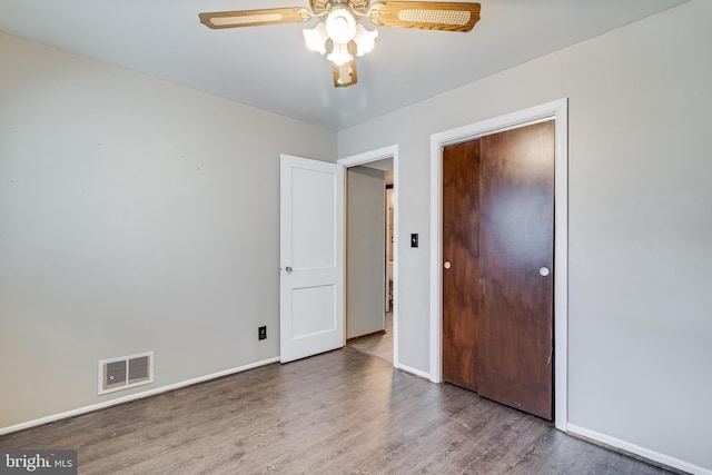 unfurnished bedroom with ceiling fan, a closet, and hardwood / wood-style flooring