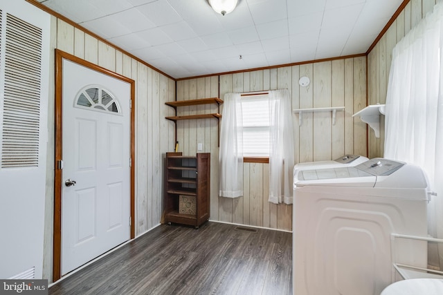 laundry area featuring wood walls, dark hardwood / wood-style floors, and independent washer and dryer