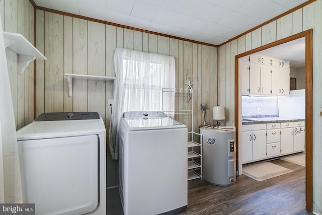 laundry room featuring electric water heater, dark wood-type flooring, wood walls, independent washer and dryer, and ornamental molding