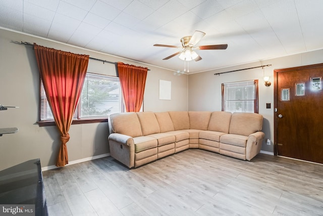 living room featuring ornamental molding, ceiling fan, and light hardwood / wood-style flooring