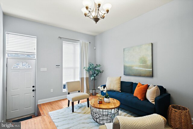 living room with light hardwood / wood-style flooring and a notable chandelier