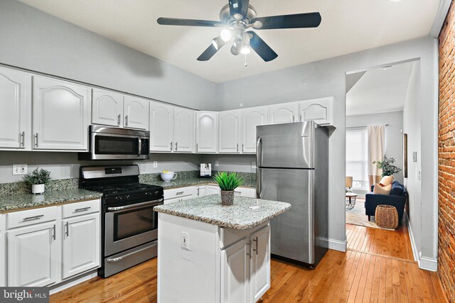 kitchen with white cabinetry, appliances with stainless steel finishes, and a kitchen island